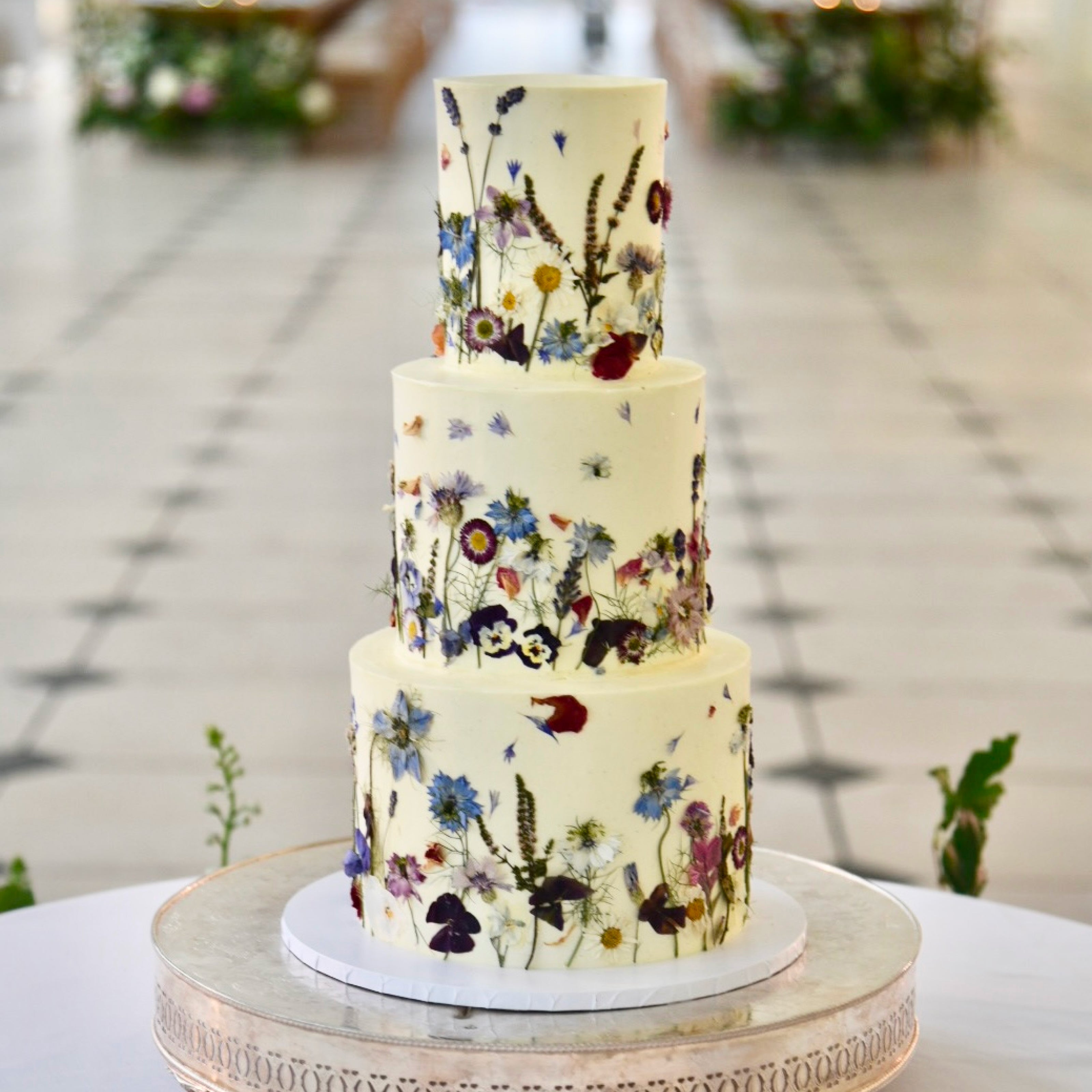 A three tier wedding cake decorated in blue flowers