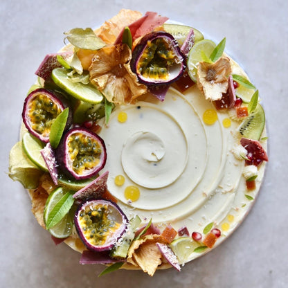 The signature passionfruit cake pictured from above decorated with natural fruit and foliage